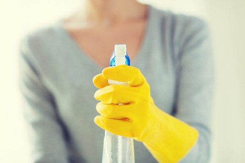 Cleaner using safe cleaning methods with equipment in a tidy indoor space