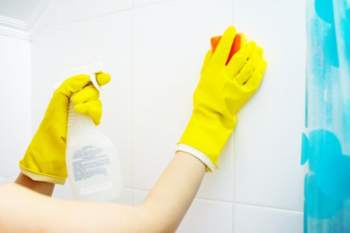 Local window cleaner working on upper-floor windows in Barnes