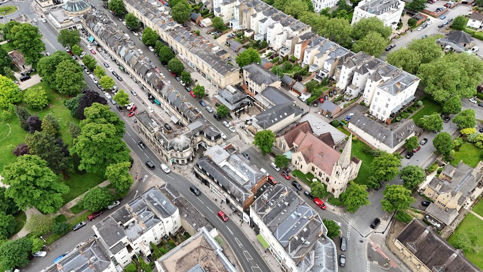 An aerial view of Barnes High Street showing a mix of commercial and residential buildings, with a Victorian-style shopping arcade prominent in the center and surrounding townhouses. The street is lin